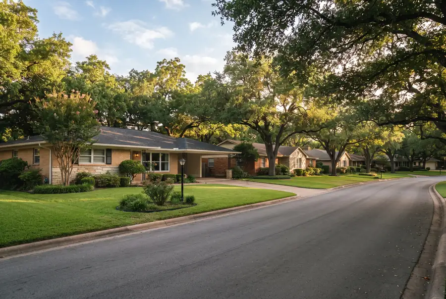 Calle residencial con árboles maduros en Castle Hills, Texas