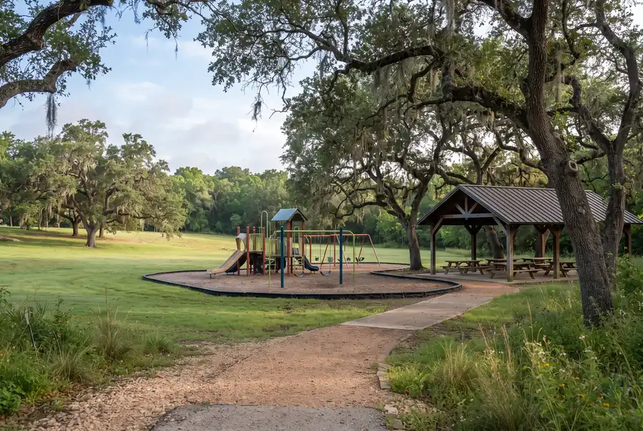Tree-shaded neighborhood park with a playground in Hollywood Park, Texas