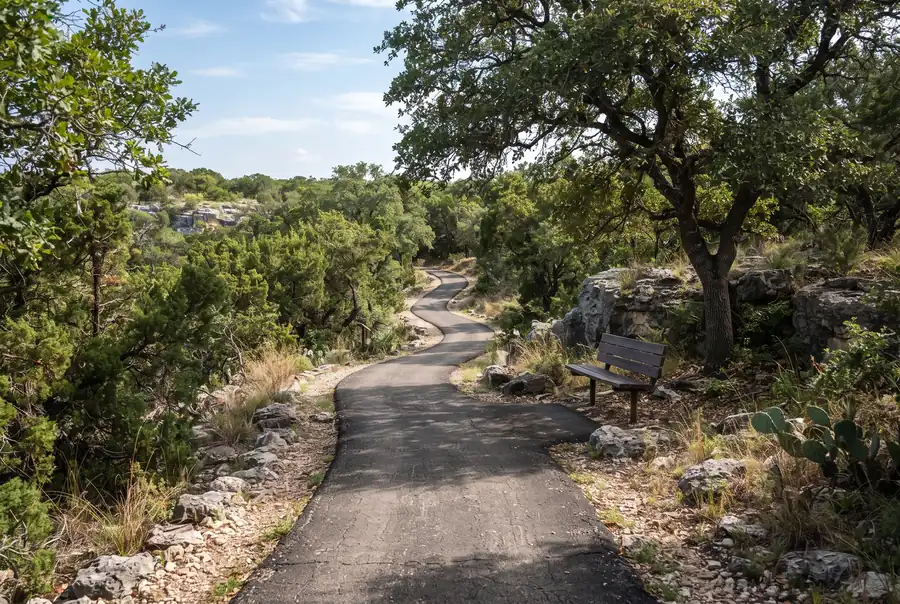 Sendero entre encinos y piedra caliza en un parque de Stone Oak, San Antonio